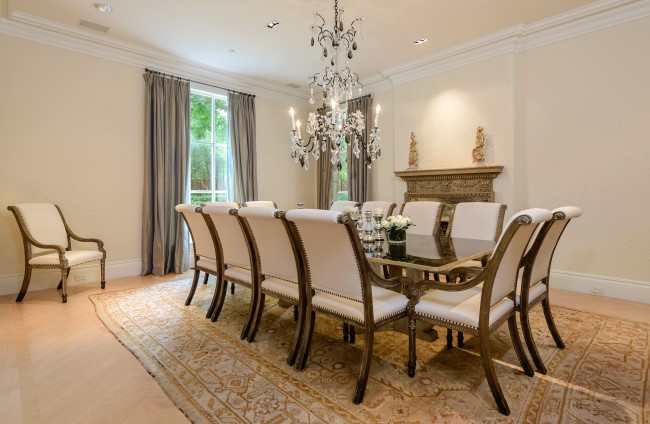 The dining room overlooks the front fountain and boasts a fireplace with unusual Symphony quartz insert, herringbone-patterned maple flooring, and crystal chandelier.